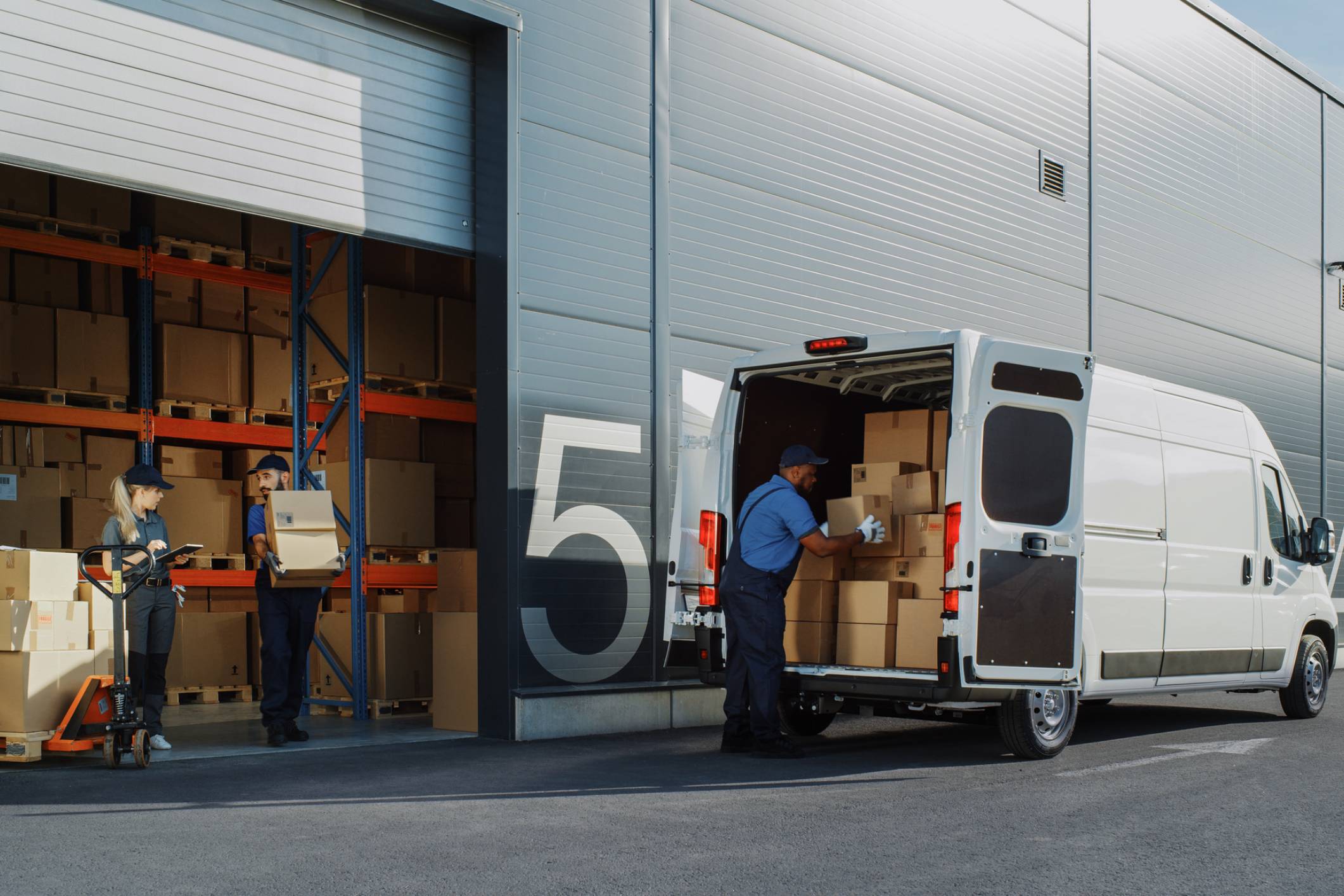 Workers loading boxes into delivery van.