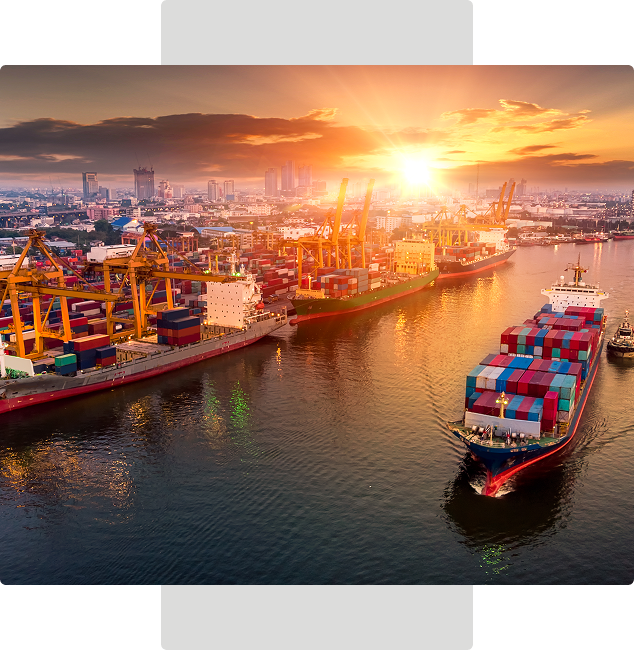 Sunset over busy port with cargo ships.